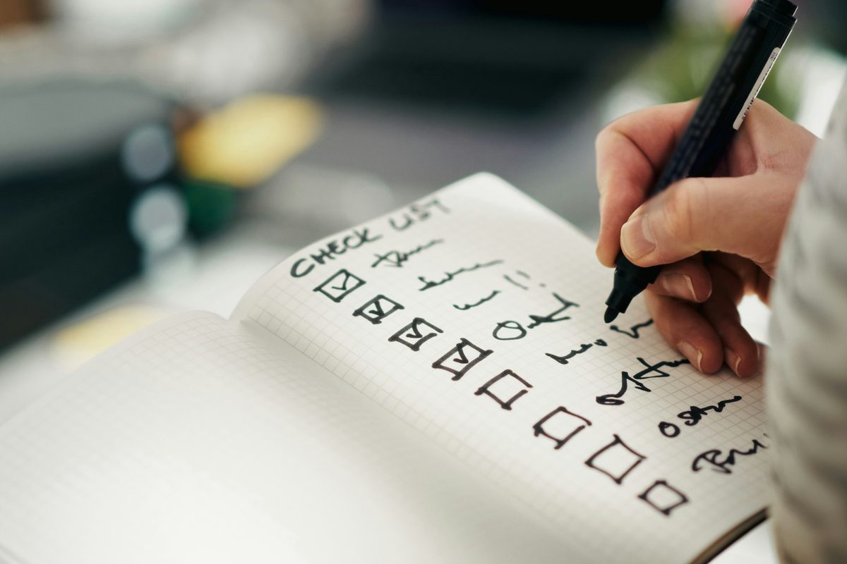Hand checking items off a checklist